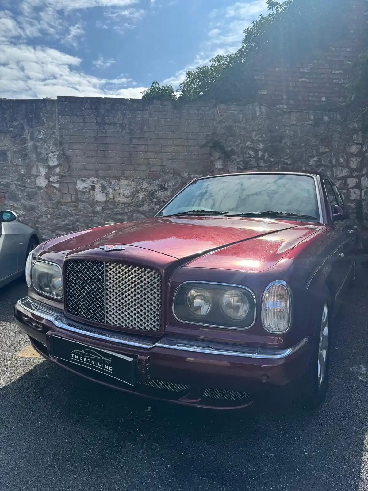 Burgundy Bentley Arnage from the front, showing the mesh grille, round headlamps and a TNDetailing plate