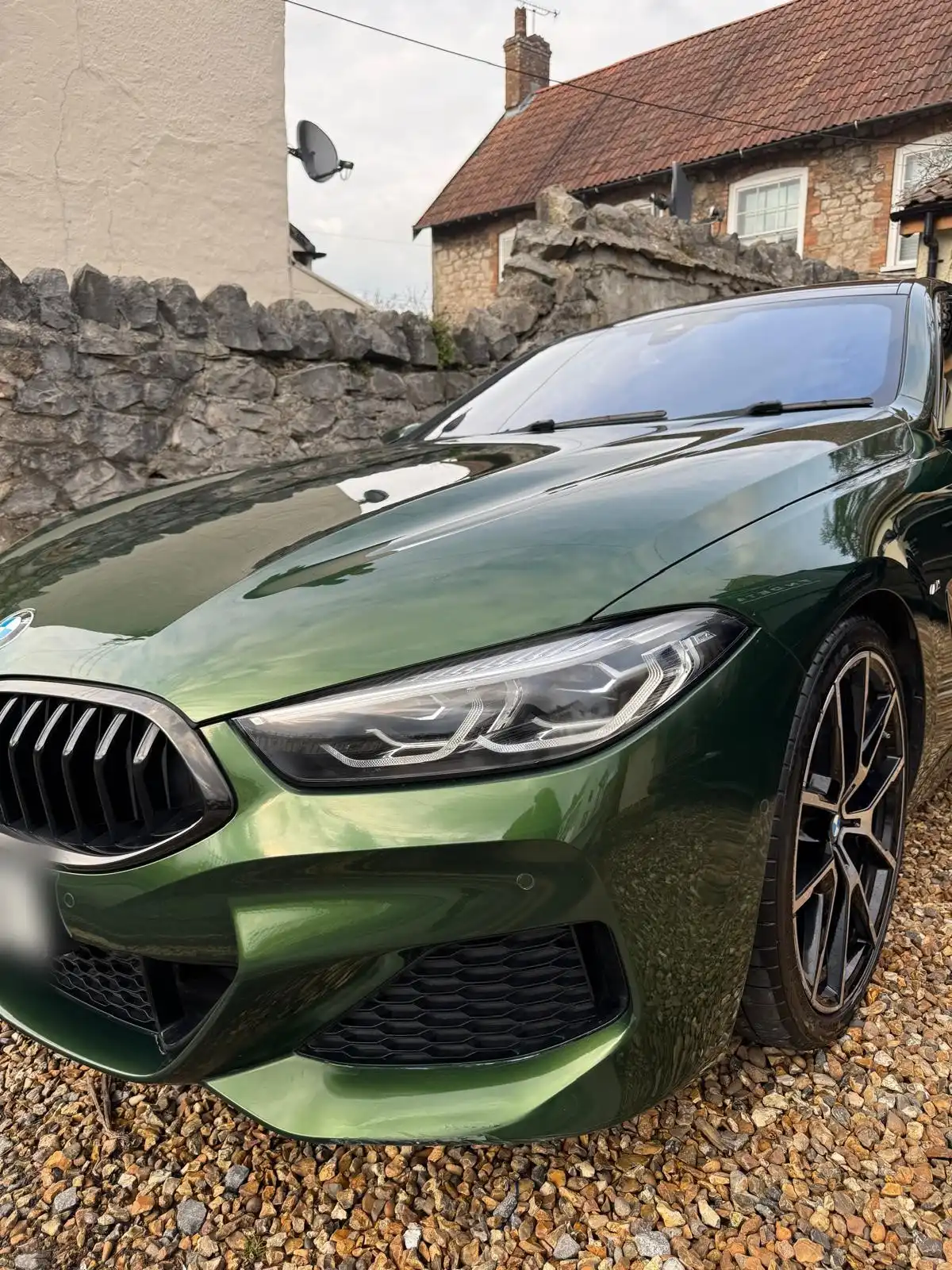 Green BMW 8 Series Gran Coupe from the front quarter, showing the gloss on the bonnet, headlamp and wheel