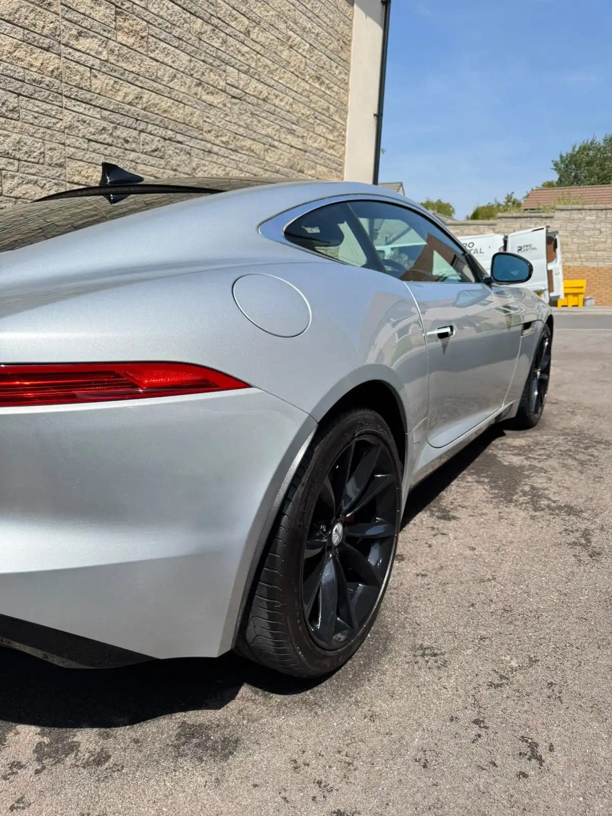 Silver Jaguar F-Type coupe from the rear quarter, showing clean, reflective paintwork