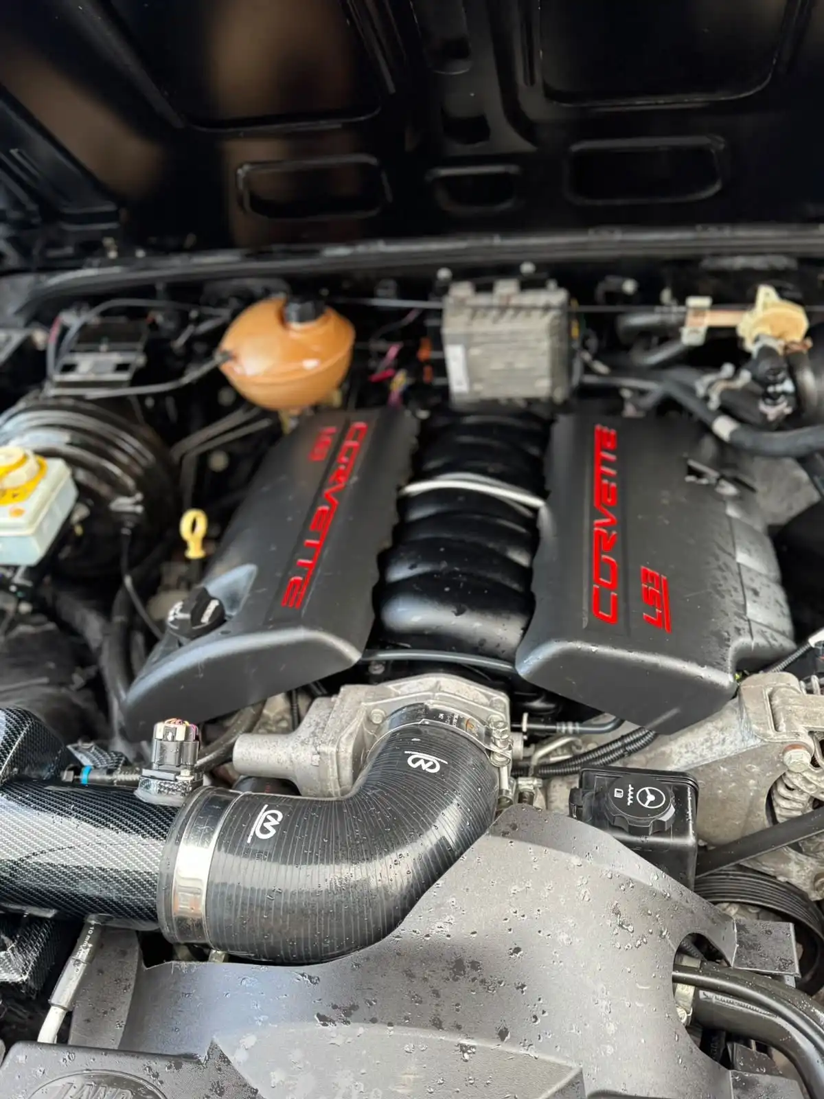 Land Rover Defender engine bay with a Corvette LS3 V8 fitted, showing the engine covers and intake