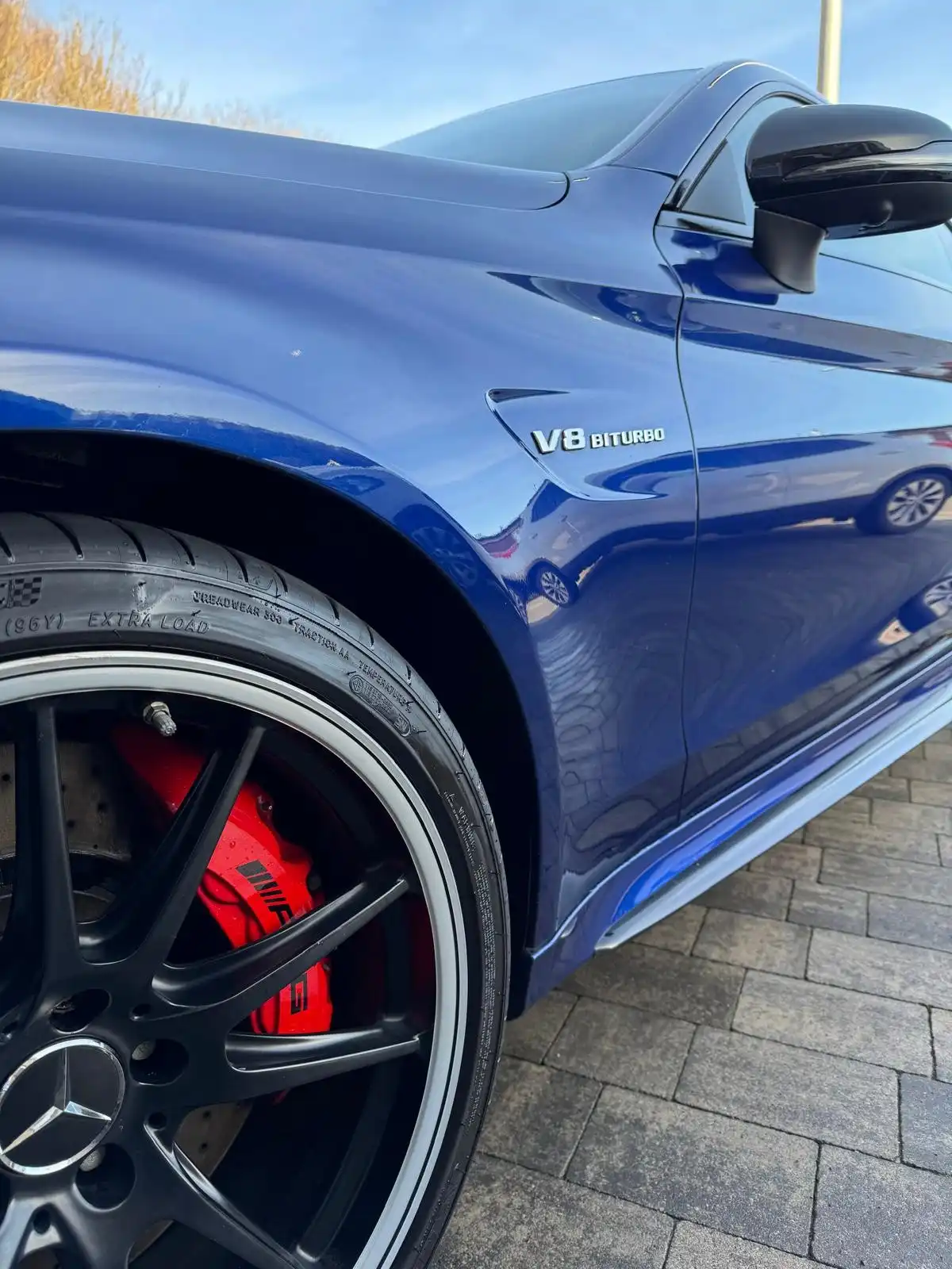 Front wing of a blue Mercedes-AMG C63 with its V8 Biturbo badge, close enough to show the depth of the paint