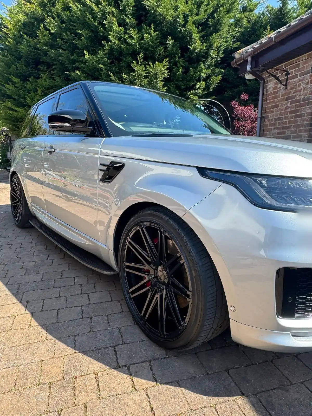 Front wing and wheel of a silver Range Rover Sport, showing the finish on the paint and the dark alloy
