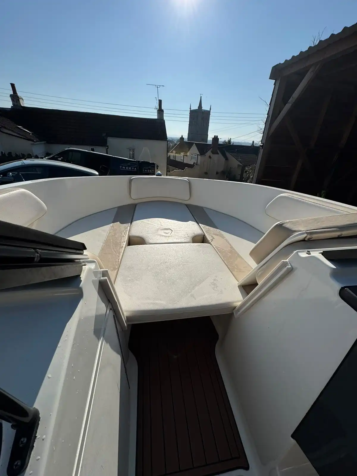 Bow seating of a speedboat, showing the cream cushions and the wood effect floor