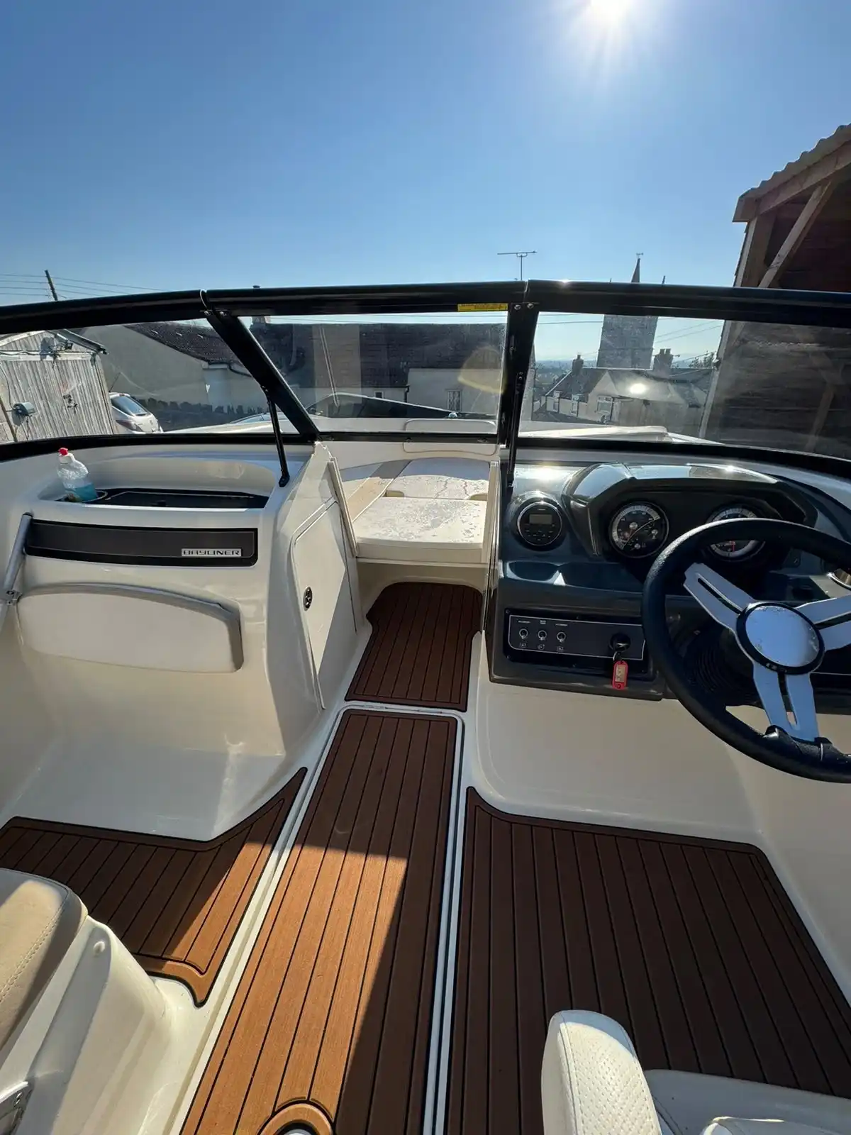 Speedboat cockpit with white upholstery and a wood effect deck, an example of boat work