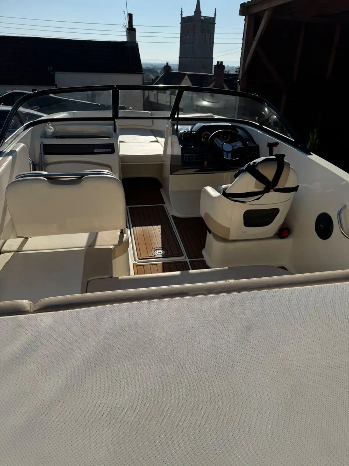 Speedboat seen from the bow, showing the helm, the seats and the wood effect deck