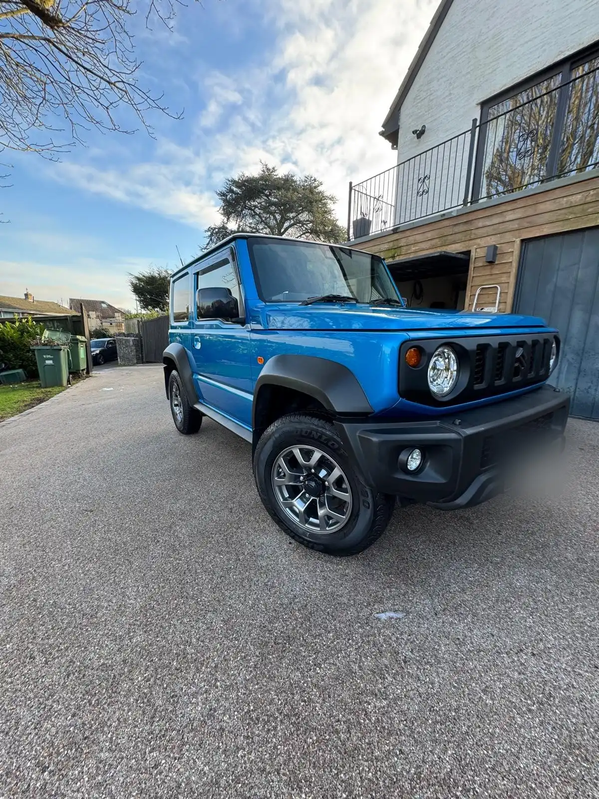 Blue Suzuki Jimny from the front quarter, showing the gloss on the blue paint