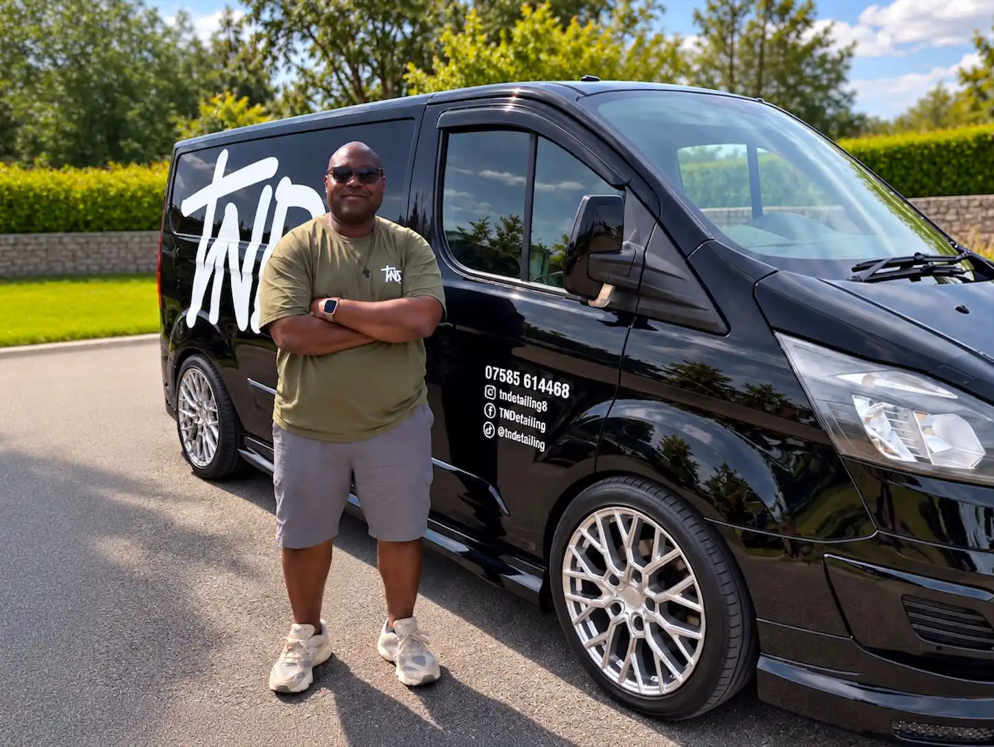 Tawaz of TNDetailing standing beside the black TNDetailing van, with the TND monogram and the phone number on its side