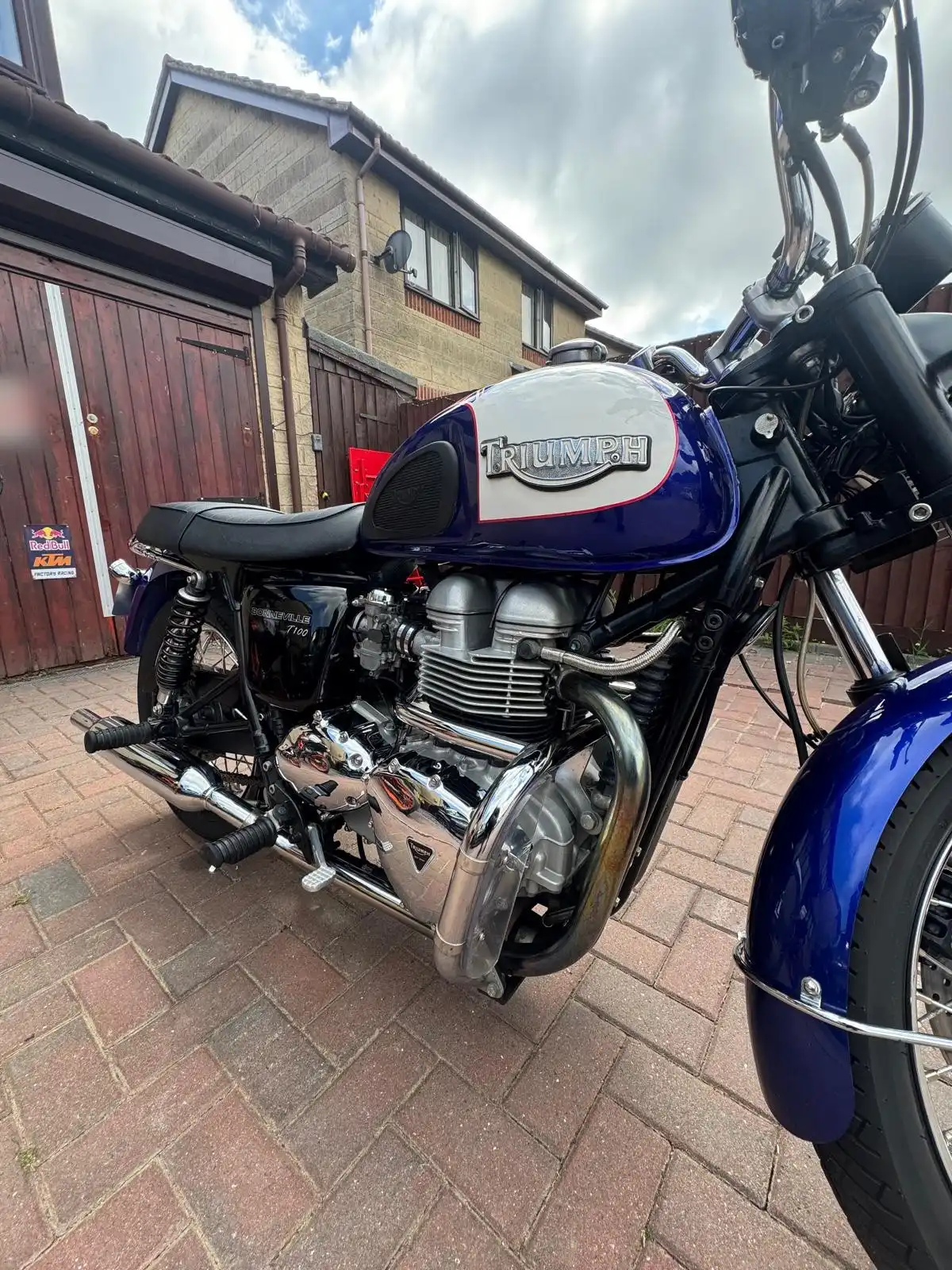 Engine side of a Triumph Bonneville T100, showing the polished chrome and the Triumph tank badge