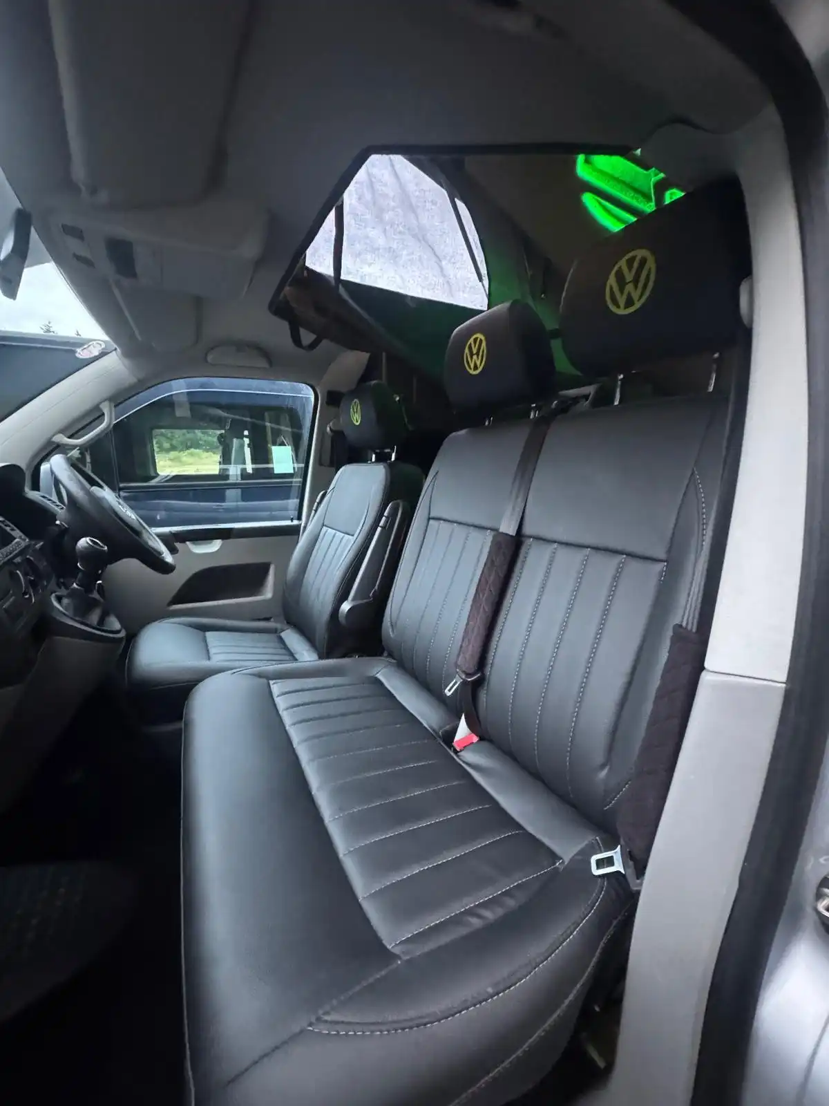 Black leather front seats with VW headrests in a Transporter camper, an example of interior work